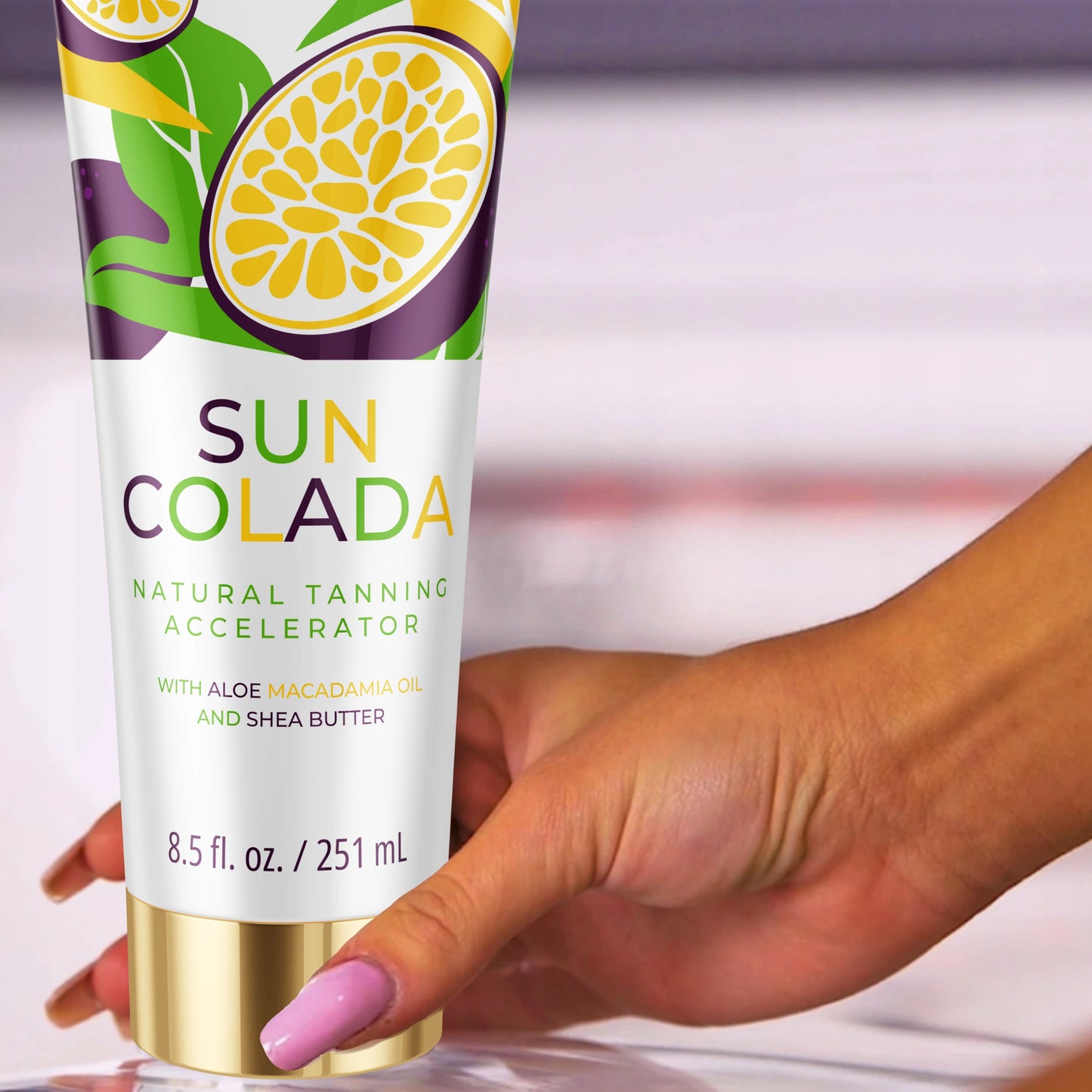 Hand hält die Onyx Suncolada Bräunungslotion in weißer und goldener Verpackung, angereichert mit Sheabutter und Macadamiaöl als ultra-feuchtigkeitsspendender Bräunungsbeschleuniger