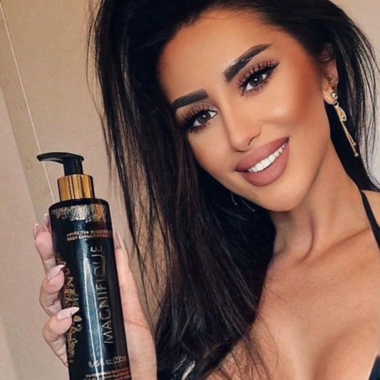 Eine Frau mit Make-up und langen dunklen Haaren hält Onyx Magnifique Bräunungscreme und lächelt in die Kamera