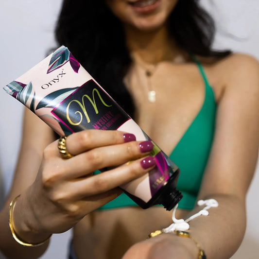 Frau im grüner Bikini trägt Onyx Mystery Bräunungslotion auf die Hand auf, Vorbereitung vor dem Sonnen im Solarium