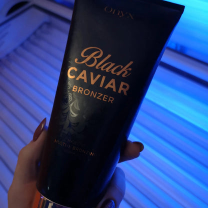 Onyx Black Caviar steht auf einer dunklen Fläche, im Hintergrund ein modernes Solarium mit rotem Licht