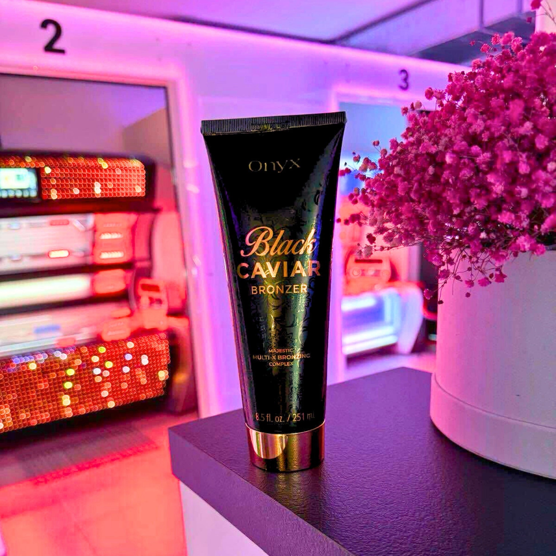 Bräunungslotion Onyx Black Caviar 251ml auf einer weißen Oberfläche vor einem gemütlichen Sofa in einem hellen Raum