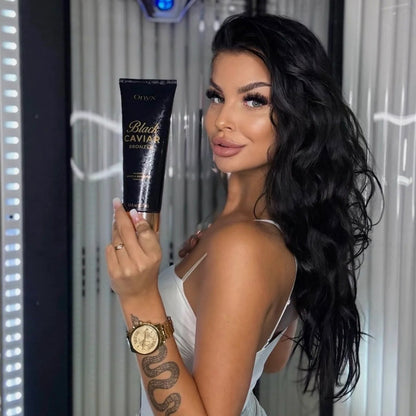 Frau hält den Onyx Black Caviar Bronzer vor einer Sonnenbank.
