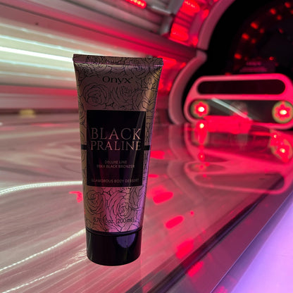 Zwei Hände halten Onyx Black Praline Lotion im bläulich beleuchteten Solarium