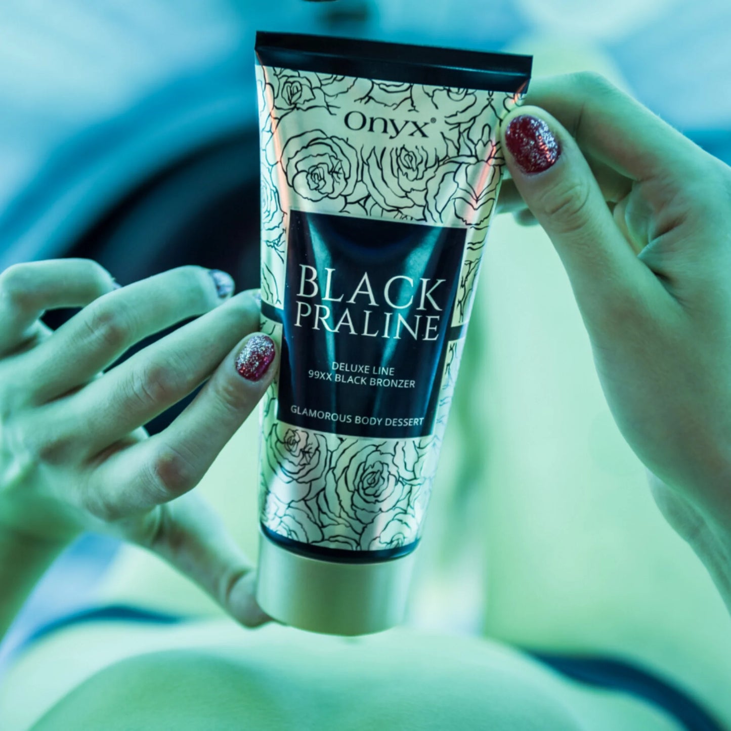 Tätowierte Frau mit orangefarbenem Top präsentiert Onyx Black Praline Lotion im Wohnzimmer