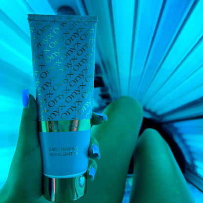 Person hält Onyx Bräunungsbeschleuniger Creme in der Hand unter blauem Solariumlicht