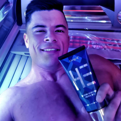 Onyx HE Bräunungslotion in Hand vor aktivierter Sonnenbank mit pinkem Licht