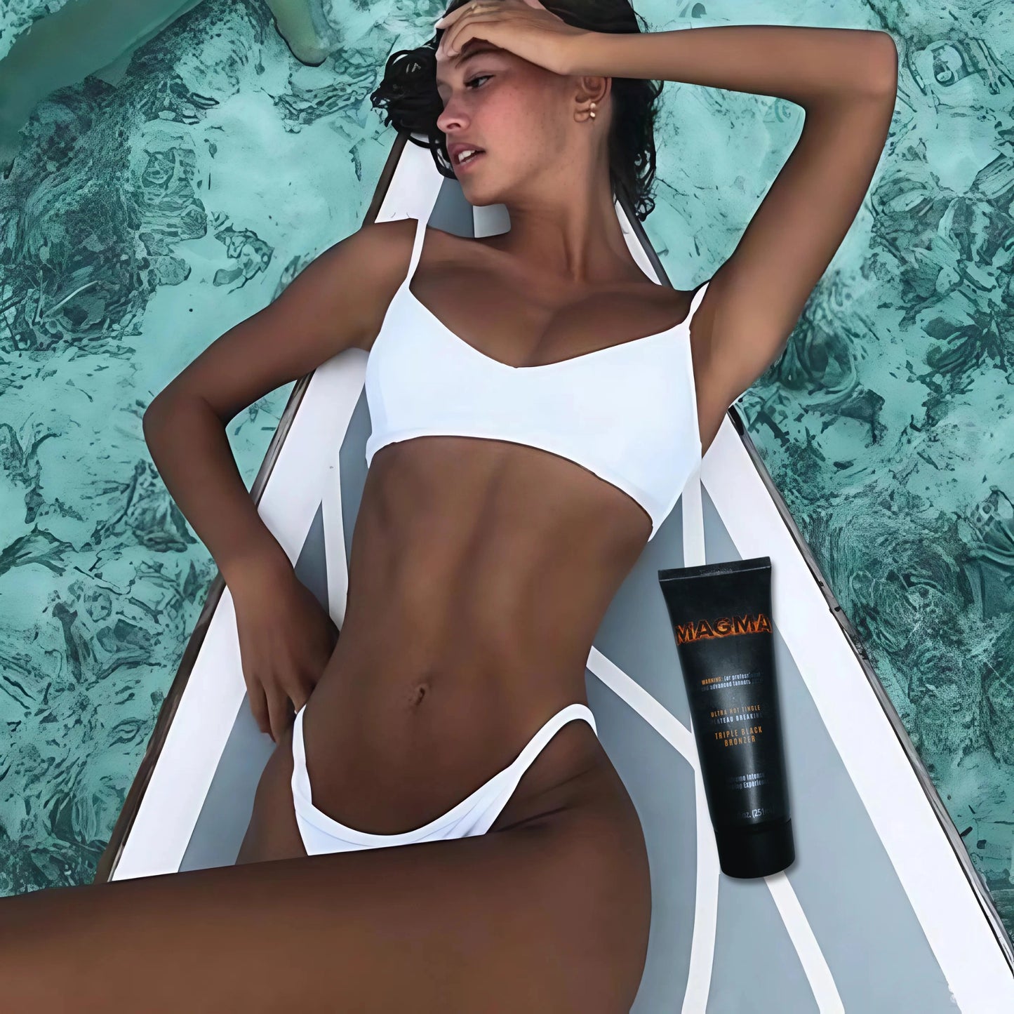 Frau im weißen Bikini liegt entspannt über türkisfarbenem Wasser, Onyx Magma Bronzer Tube neben ihr