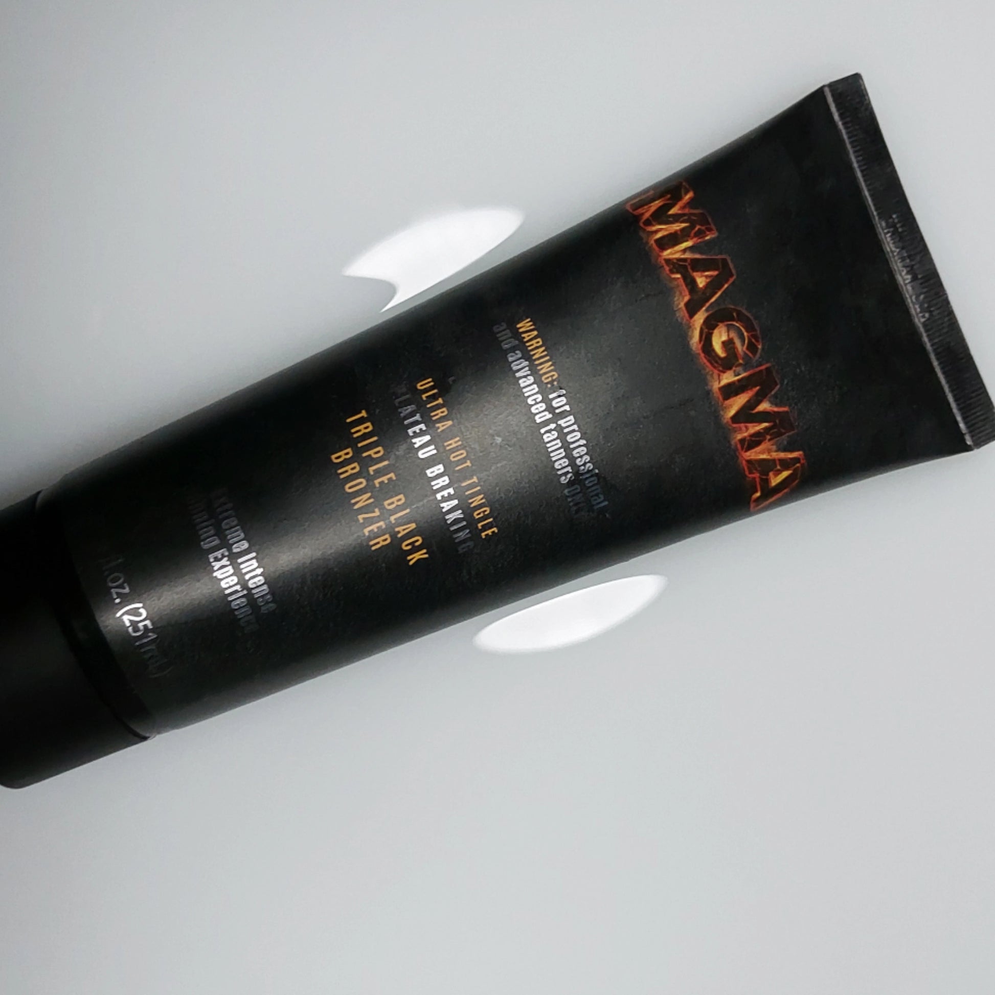 Onyx Magma Triple Black Bronzer Tube flach auf weißem Hintergrund mit reflektierendem Licht fotografiert