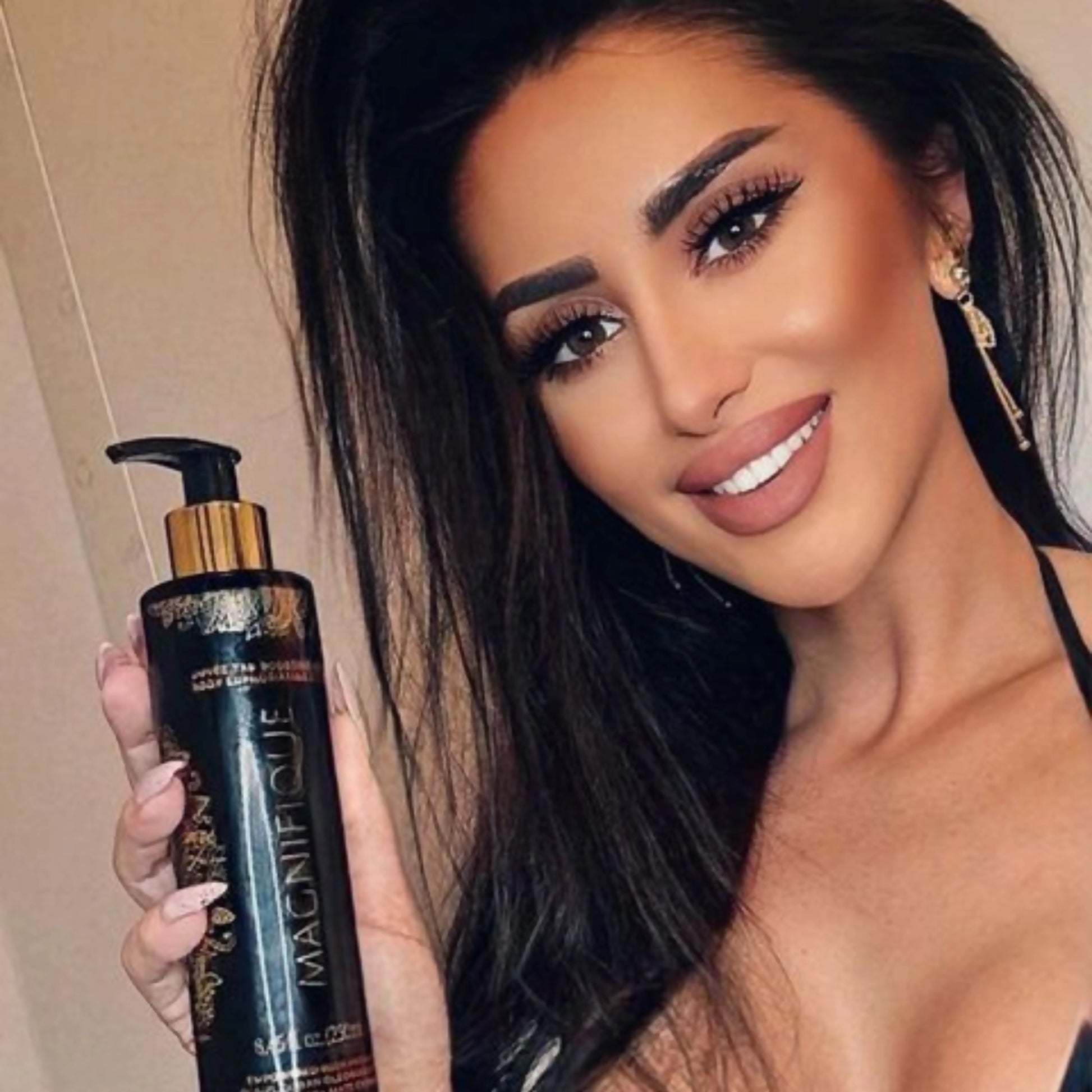 Hand hält Onyx Magnifique Bräunungselixier in einer Sonnenbank mit pink-blauer Beleuchtung – ideal für Indoor-Bräunung
