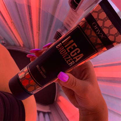 Hand mit pink lackierten Nägeln hält Mega Bronzer Lotion im rot beleuchteten Solarium, zeigt Anwendung in Echtzeit