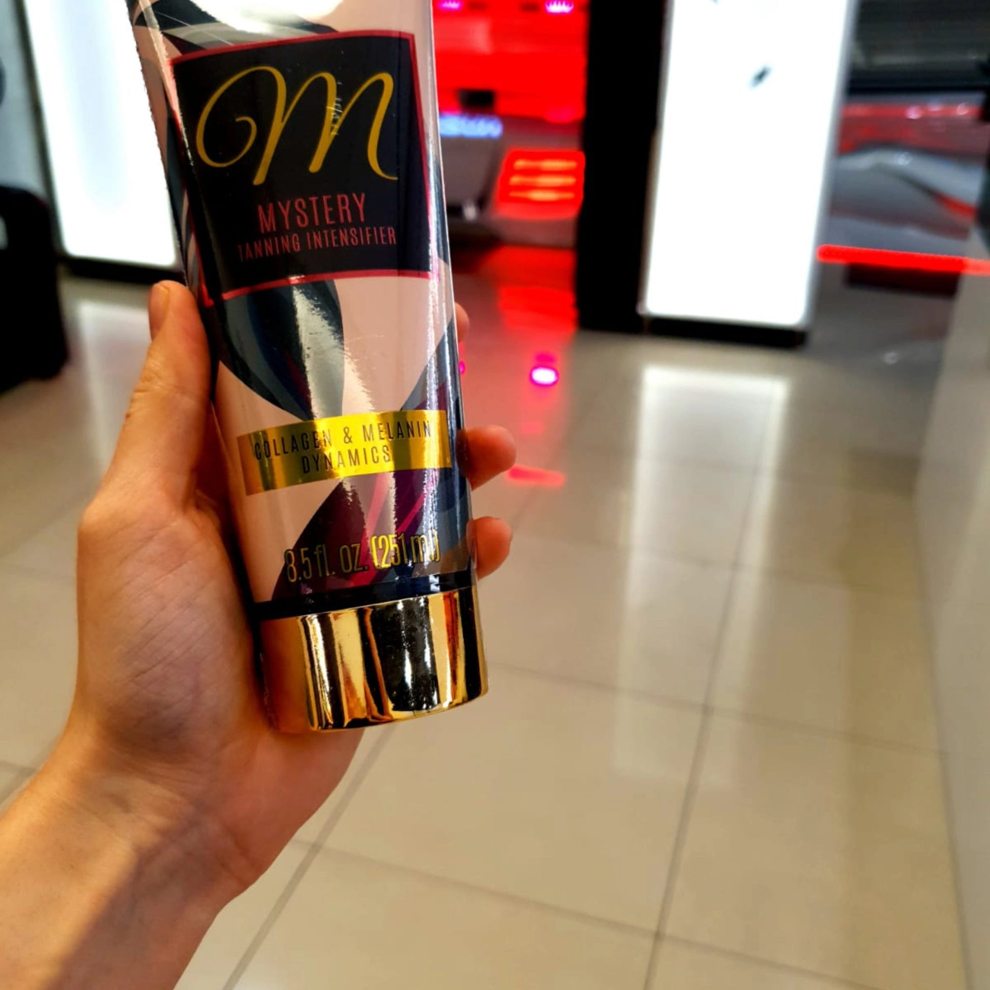 Onyx Mystery Bräunungslotion auf den Beinen einer Frau mit Fokus auf das elegante Verpackungsdesign