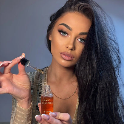 Frau mit dunklen Haaren und Make-up hält SUNL ESSENCE Selbstbräunungsdrops und Pipette in der Hand