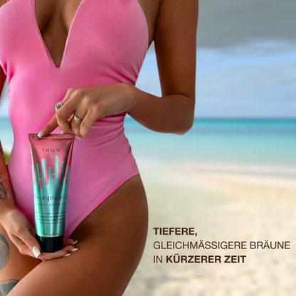 Frau im pinken Badeanzug am Strand haelt Onyx Sunphoria, eine Bräunungslotion fuer eine intensivere und gleichmaessige Bräune in kuerzerer Zeit.
