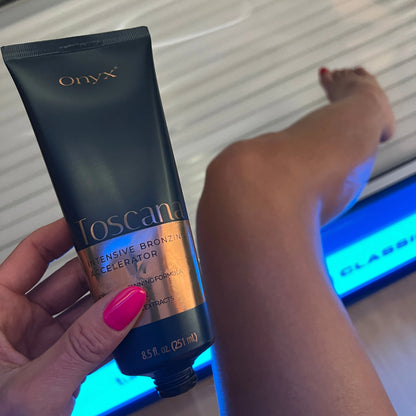 Geöffnete Onyx Toscana Tube vor Bein im Solarium mit pink lackierten Nägeln